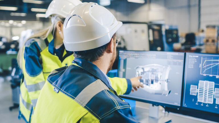 At the Factory: Male Mechanical Engineer and Female Chief Engineer Work Together on the Personal Computer, They Discuss Details of the 3D Engine Model Design.